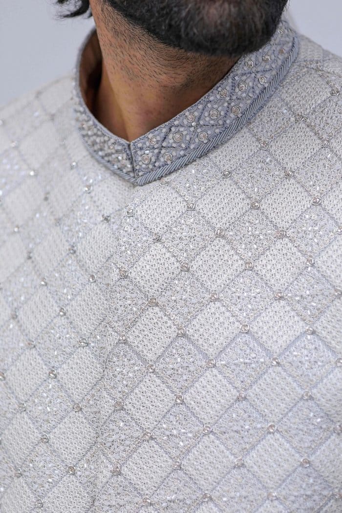 Close-up of embroidery and buttons on light grey sherwani front panel