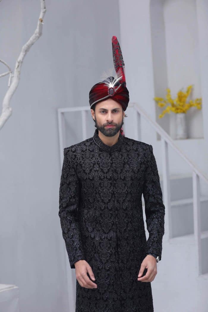 Front view of black sherwani with intricate embroidery and buttons