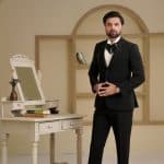 Groom wearing black two piece suit with handmade embroidery
