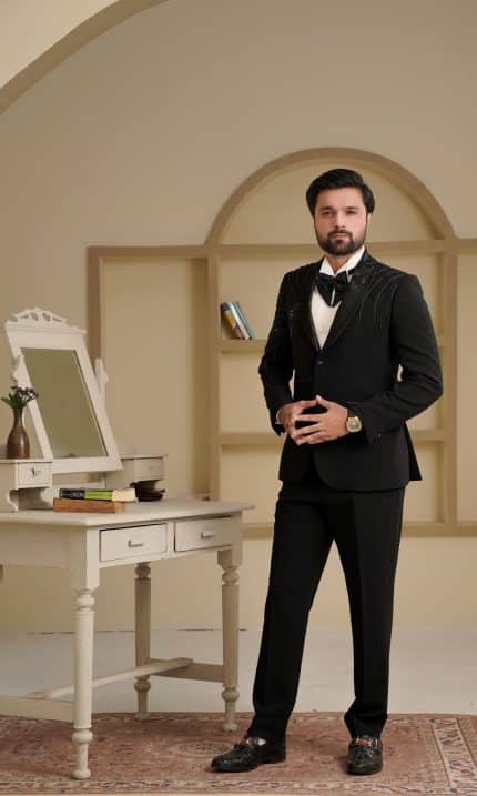 Groom wearing black two piece suit with handmade embroidery