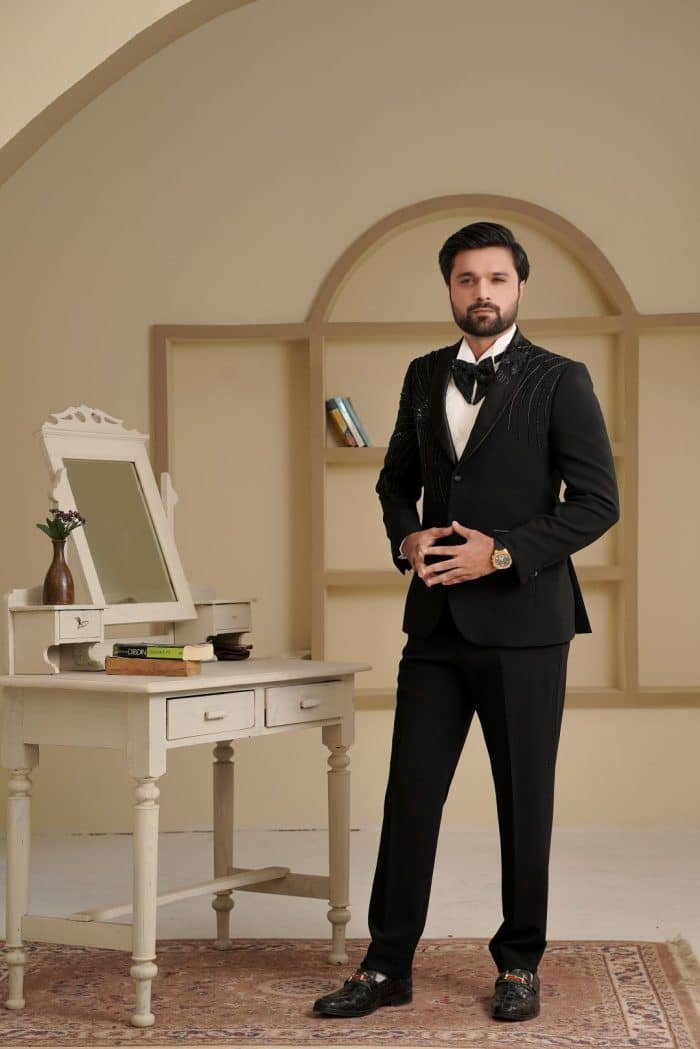 Groom wearing black two piece suit with handmade embroidery