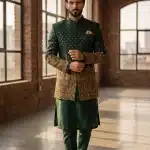 Crafted from premium jamawar fabric, this prince coat reflects timeless elegance with a modern touch. The rich texture is enhanced by intricate digital thread embroidery, beautifully detailed on the sleeves and lower panel, giving it a luxurious and regal appearance.