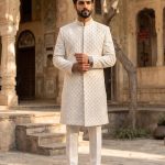 Off-white handmade embroidered groom sherwani with floral detailing and band collar.