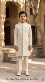 Young boy wearing an off-white plain silk sherwani with elegant digital thread embroidery and matching trousers.