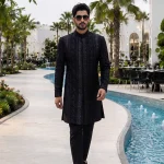 Black sherwani with handmade digital thread embroidery for groom wedding wear.